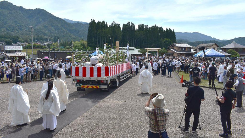 御神木を載せたトラックを木遣音頭が先導して、護山神社を出発する様子